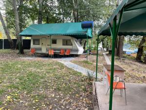 塞格德Tisza beach Wild Camping 2的公园里带蓝篷的露营车