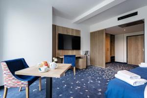 KrzeIlkus Hotel & Restaurant的酒店客房设有两张床和一张桌子。