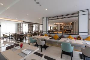 班昌Kantary Hotel Banchang的餐厅设有桌椅和大镜子