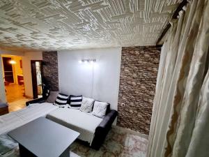 Razgradтри стаен лукс апартамент的一间带床和砖墙的客厅
