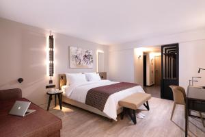 塞萨洛尼基S Hotel Boutique Thessaloniki的配有一张床和一张书桌的酒店客房