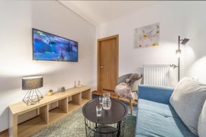 捷克布杰约维采Aviatik apartments的客厅配有蓝色的沙发和桌子