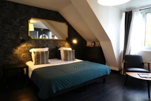 孔卡尔诺La Villa des Sables的一间卧室配有一张带镜子和椅子的床