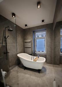 莱比锡Flat in neo country style aus Gründerzeit bis 6 Person的带浴缸和玻璃淋浴间的浴室。