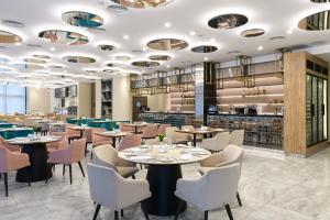敖德萨Premier Hotel Odesa的一间带桌椅的餐厅和一间酒吧