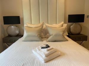 卡迪夫Exclusive Cardiff City Centre Apartment的一张带毛巾的白色床和两盏灯