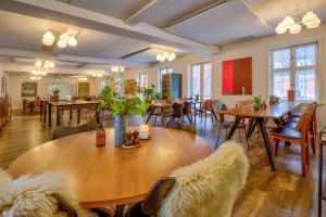 Skarrild斯凯里尔之家西纳图尔会议中心酒店的餐厅设有木桌、桌椅和窗户。