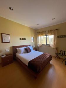 塔布阿苏Casa da Quinta的一间卧室设有一张大床和一个窗户。