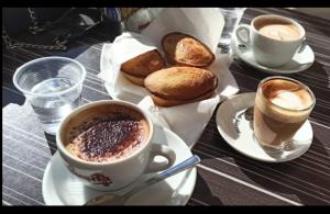 莱切Dei Due Portoni Suite Storica的一张桌子,上面放着两杯咖啡和一些面包