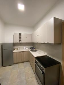 斯科普里R&K Hostel的厨房配有白色橱柜、水槽和炉灶。