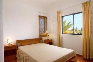 珀彻斯Apartamento Vila Mourisca的一间卧室设有一张床和一个大窗户