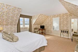 Strachur克里甘斯酒店的卧室配有一张白色大床和一张书桌