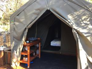 Hartebeest RivierOtium Oasis Glamping & Camping的帐篷配有一张床和一张桌子