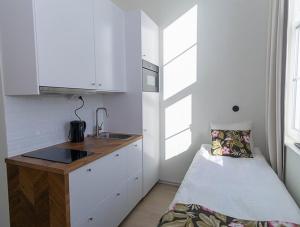 RosersbergDéus Longstay的白色小厨房配有水槽和床