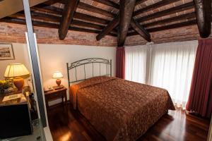 帕多瓦贝托里尼公寓式酒店的一间带一张床的卧室,位于带木制天花板的房间内