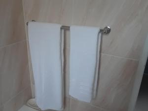 卡萨内Ramatie Guest Palace的浴室内毛巾架上挂着两条白色毛巾