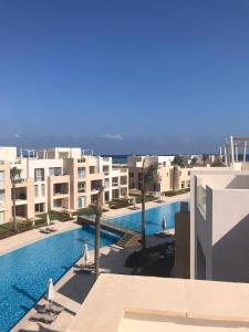 赫尔格达Jutta Deluxe 2-Bedroom-Apartment Mangroovy-M7 El Gouna的从大楼的阳台上可欣赏到游泳池的景色