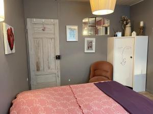 圣阿沃尔德Jardin Secret au Cœur de la Dourd’halie的卧室配有粉红色的床和白色冰箱。