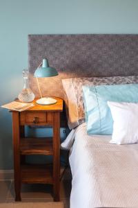 埃斯克尔Las Bayas Home Suites的一张带桌子的床,上面有台灯