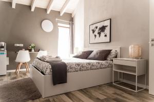 维佐拉提契诺Via Mazzini B & B (MXP)的白色的卧室设有一张大床和一个窗户
