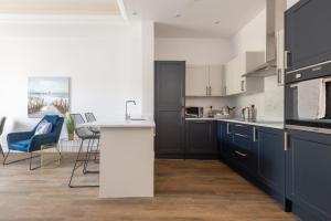 圣安德鲁斯Skye Sands - Swilken Garden Residence - St Andrews的厨房配有蓝色橱柜和白色台面