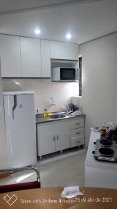 圣保罗Flat com Sacada - Região Ibirapuera próximo vários Hospitais e UNIFESP的厨房配有白色橱柜和白色冰箱。