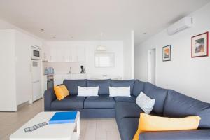 普拉亚布兰卡Blancazul Harbour View的一间带蓝色沙发的客厅和一间厨房