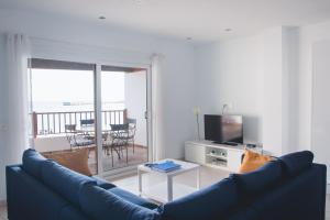 普拉亚布兰卡Blancazul Harbour View的客厅配有蓝色的沙发和电视