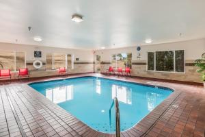 塞奎姆奥林匹克国家公园红狮旅馆及套房酒店的酒店客房内的大型游泳池配有红色的椅子和桌子