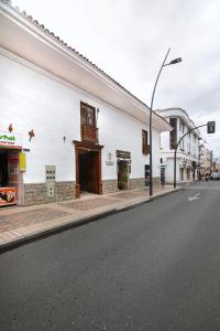 洛哈Casa Bolívar Hotel Museo的一条空的街道,有白色的建筑