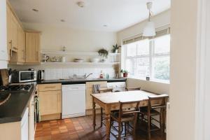 肯德尔SUNNYSIDE APARTMENT - Spacious 2 Bedroom Ground Floor with Free Parking In Kendal, Cumbria的厨房配有桌子和一些椅子