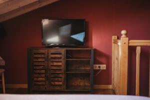 CardesCasa Rosales ( Posada Rural)的卧室内木柜里的电视