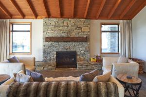 特卡波湖Lake Lodge - Lake Tekapo的带沙发和石制壁炉的客厅