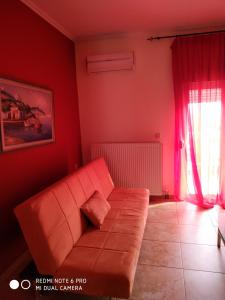里托楚伦La betia的客厅设有橙色沙发和红色墙壁。