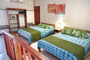 萨拉皮基La Quinta Sarapiqui Lodge的酒店客房设有两张床和一个阳台。