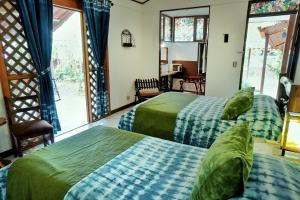 萨拉皮基La Quinta Sarapiqui Lodge的带2扇窗户的客房内的2张床