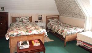 威克楚慕斯特旅馆的一间卧室配有两张床和一张桌子,备有书籍