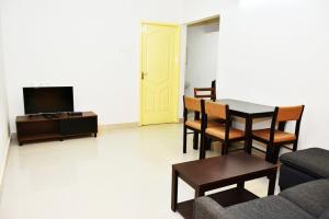 钦奈Chippy Apartments 3006B的客厅配有桌椅和电视。