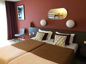 托农莱班巴拉丁斯公寓酒店的配有一张大床和镜子的酒店客房