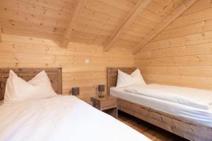 ElsenbrunnHoliday village Koralpe St- Stefan im Lavanttal - OKT07003-FYD的木墙客房的两张床