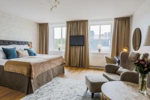 韦克舍克拉丽奥卡迪纳尔连锁酒店的一间卧室配有一张床、一张沙发和一台电视。