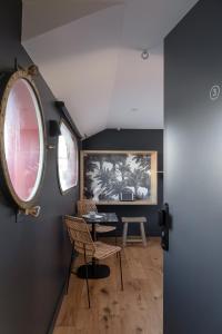 罗纳河畔的图尔农LA PENICHE - Bed And Bicycle - Tournon的客房设有桌子、椅子和窗户。