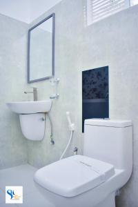 波隆纳鲁沃Hotel Summer Haven的浴室配有白色卫生间和盥洗盆。