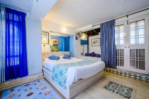 尼玛纳尼梅拉堡-宫殿酒店的一间拥有蓝色墙壁的卧室和一张带蓝色窗帘的床