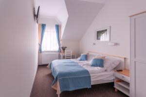 Murowana Goślina考斯特拉城堡旅舍的一间卧室配有一张带蓝色毯子的床
