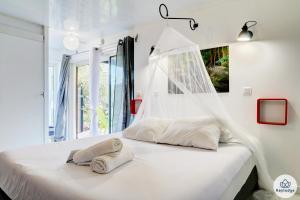莱萨维龙Le Bambou - 2 étoiles - Les Avirons的白色卧室设有一张带窗户的床