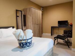 Ban Song HongThe Lantern Suites的酒店客房,配有一张带毛巾篮的床