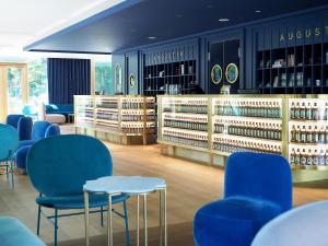 慕尼黑Jugend- und Familienhotel Augustin的一间商店,里面摆放着蓝色的椅子和瓶装葡萄酒