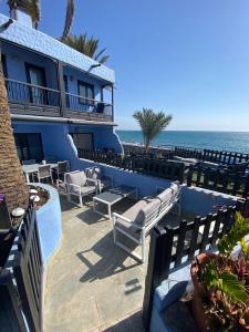 马斯帕洛马斯Bungalow Playa del Aguila的一个带椅子的度假庭院和背景海洋