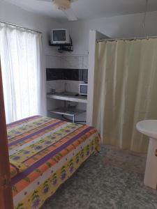 格兰贝伊Obelix Apartment的卧室配有一张床,墙上配有电视。